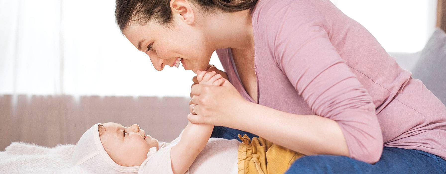 Frau lacht das Baby an