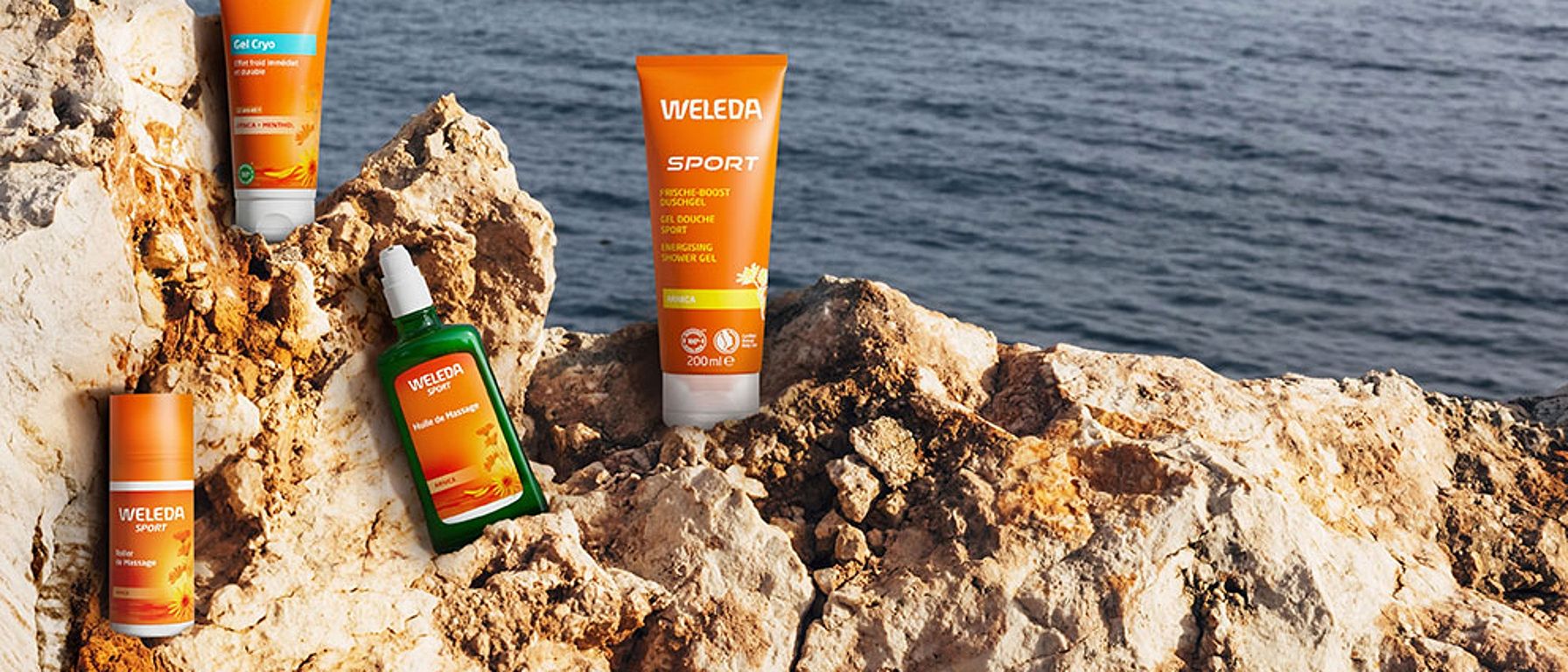 Weleda Arnika Produkte auf einem Felsen am Meer