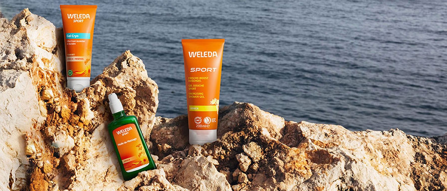 Weleda Arnika Produkte auf einem Felsen am Meer