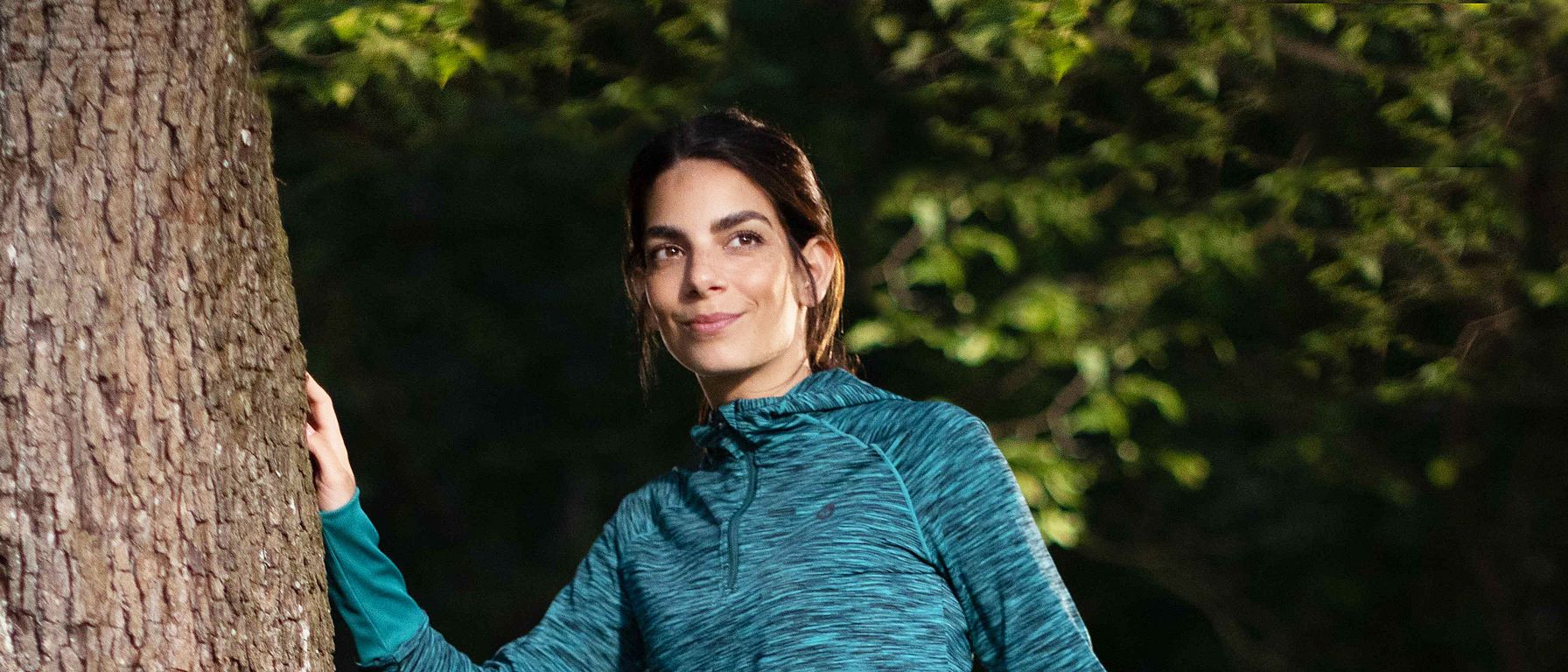 Sportliche Frau am Baum