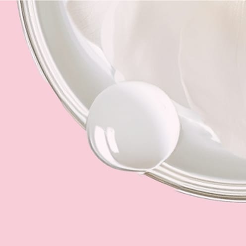 Weiße Creme in einer Dose auf rosa Hintergrund