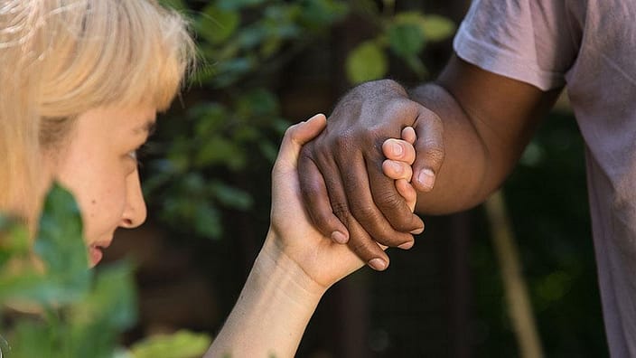 Eine Frau haelt die Hand eines Mannes