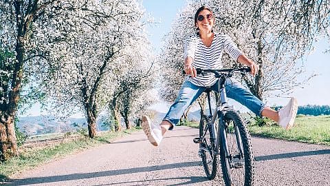 Frau im Frühling auf dem Fahrrad