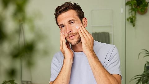 Mann pflegt sein Gesicht