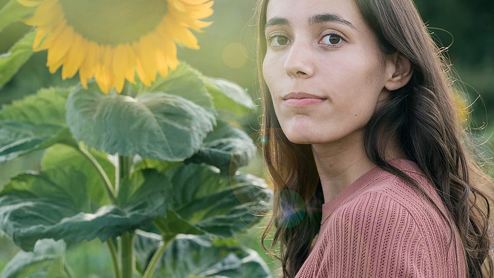 Frau in einem Sonnenblumenfeld an einem sonnigen Tag