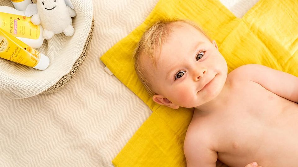 Baby liegt auf einer gelben Decke