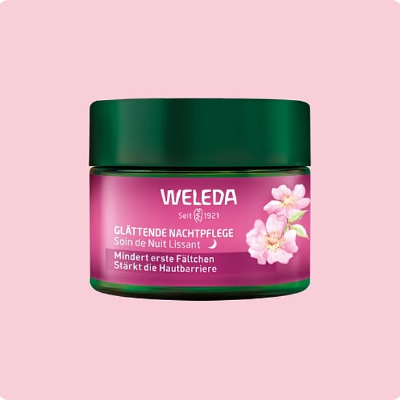 Weleda Glättende Nachtpflege vor einem rosa Hintergrund