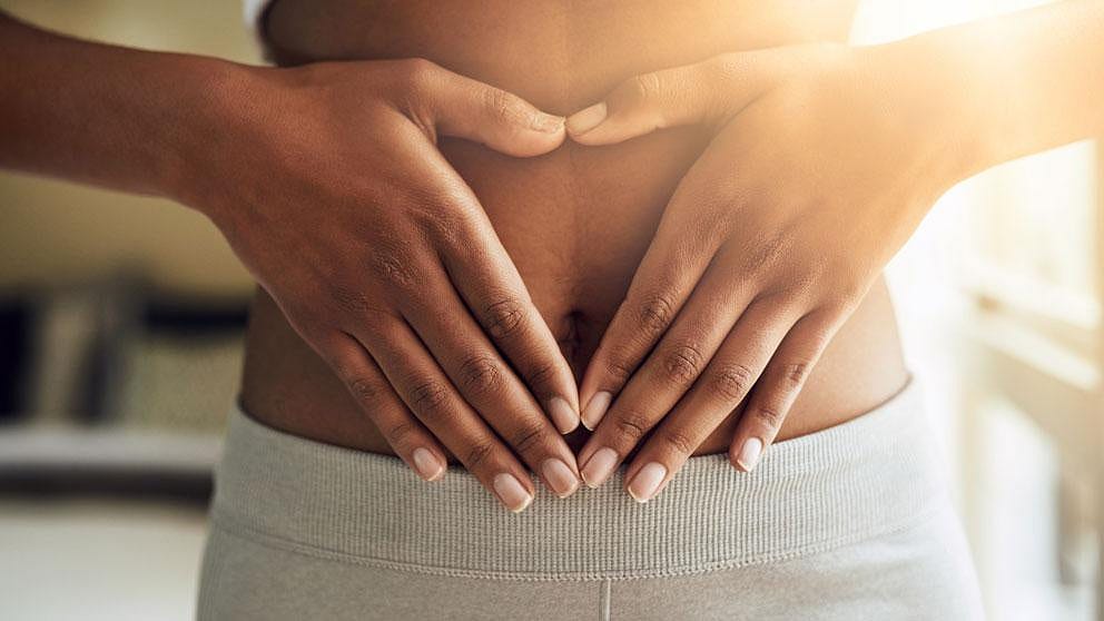 Frau legt die Hände auf den Bauch