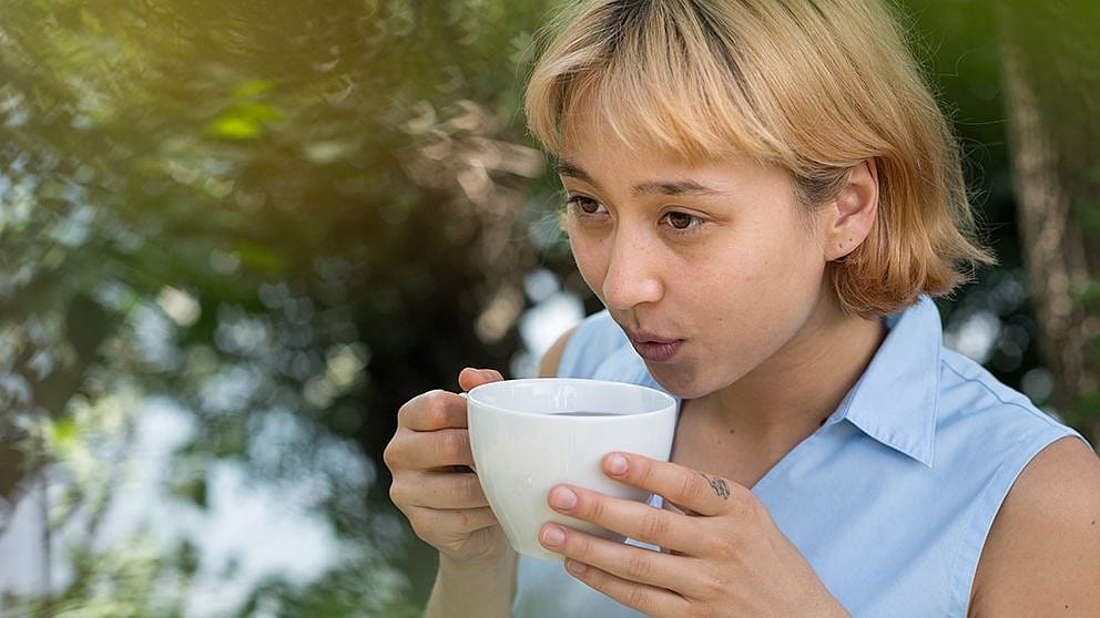 Frau trinkt Tee im Garten