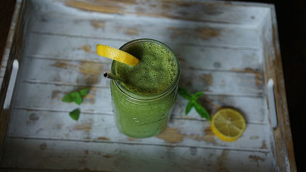 Grüner Smoothie mit Zitrone auf dem Tisch